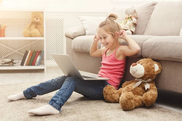 Belle enfant féminin jouant jeu en ligne sur ordinateur portable — Photo