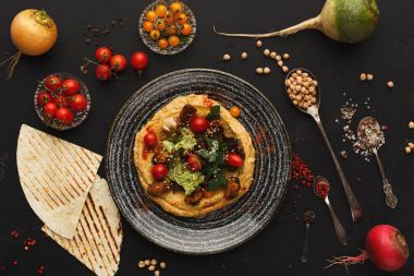 Humus sebze ve siyah arka plan üzerine deniz ürünleri ile