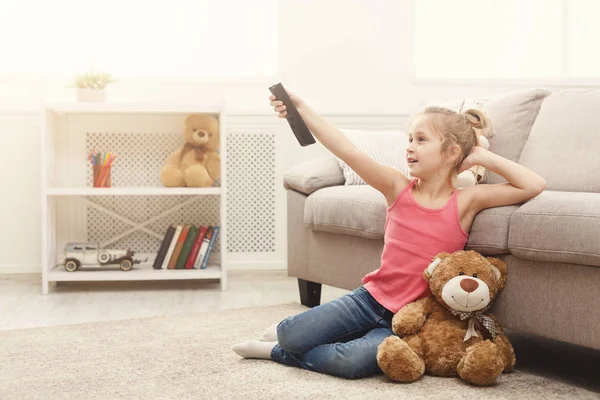 Krásné ležérní holčička, sledování televize, zatímco sedí na podlaze doma — Stock fotografie