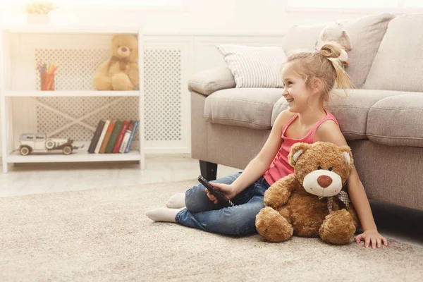 집에서 바닥에 앉아있는 동안 tv를 보고 아름 다운 캐주얼 어린 소녀 — 스톡 사진