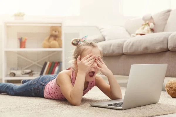 Félek, néz film a laptop, miközben feküdt a padlón otthon alkalmi kislány — Stock Fotó