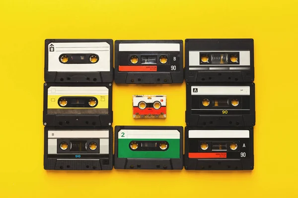 Великі ретро-касети, що обрамляють маленький на жовтому тлі, вид зверху, простір для копіювання — стокове фото