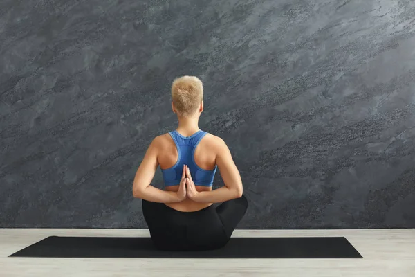 Young woman in yoga class, Reverse Prayer Pose