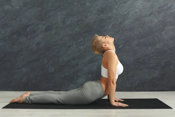 Kvinnan utbildning yoga i cobra pose. — Stockfoto