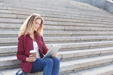 Bir dizüstü bilgisayarda çalışan ve içme kahve dışında öğrenci kız