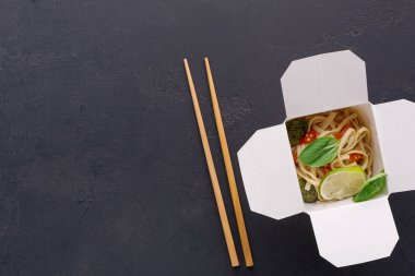 Gri arka plan üzerinde teslim kutusundaki Asya gıda