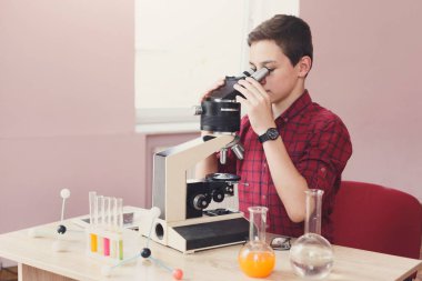 Okul çocuğu mikroskobu ders üzerinde seyir