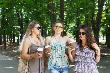 Üç güzel genç boho chic şık kız Parkta yürümek.