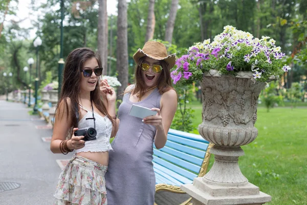 Retrato al aire libre de dos amigos viendo fotos con un teléfono inteligente — Foto de Stock