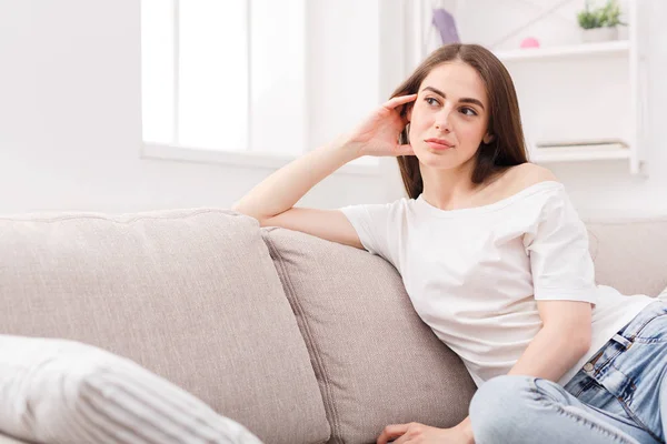 Ung eftertänksam kvinna sitter på soffa — Stockfoto