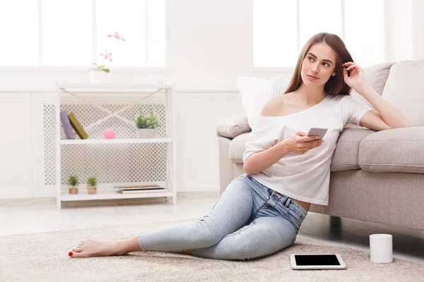 Pensive girl with mobile on the floor — Stock Photo, Image