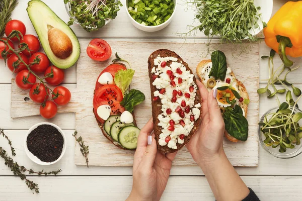 Woman making tasty bruschettas for healthy snack, top view — Stock Photo, Image