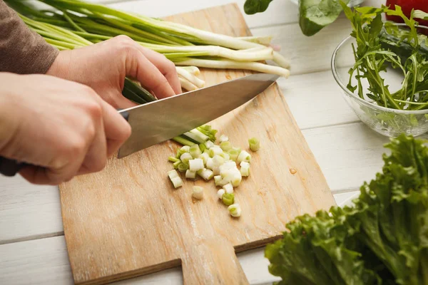 Vrouw snijden lente-ui voor salade — Stockfoto