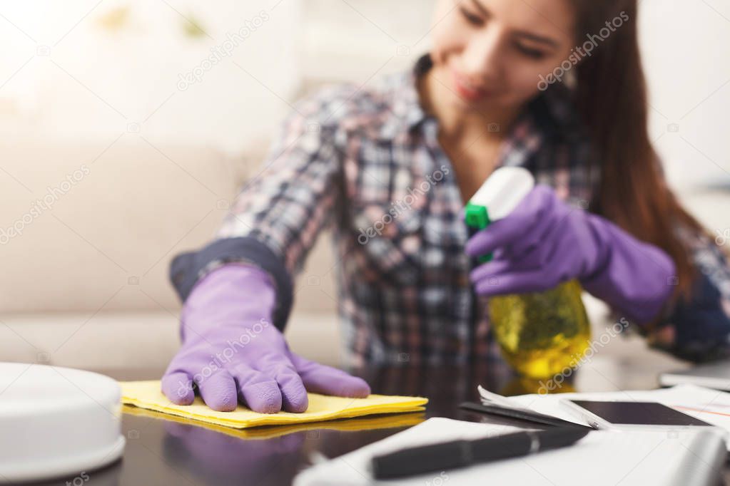 Woman using spray cleaner on wooden surface