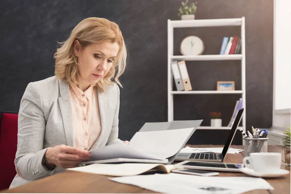 Affärskvinna som läser dokumentet på office desktop — Stockfoto