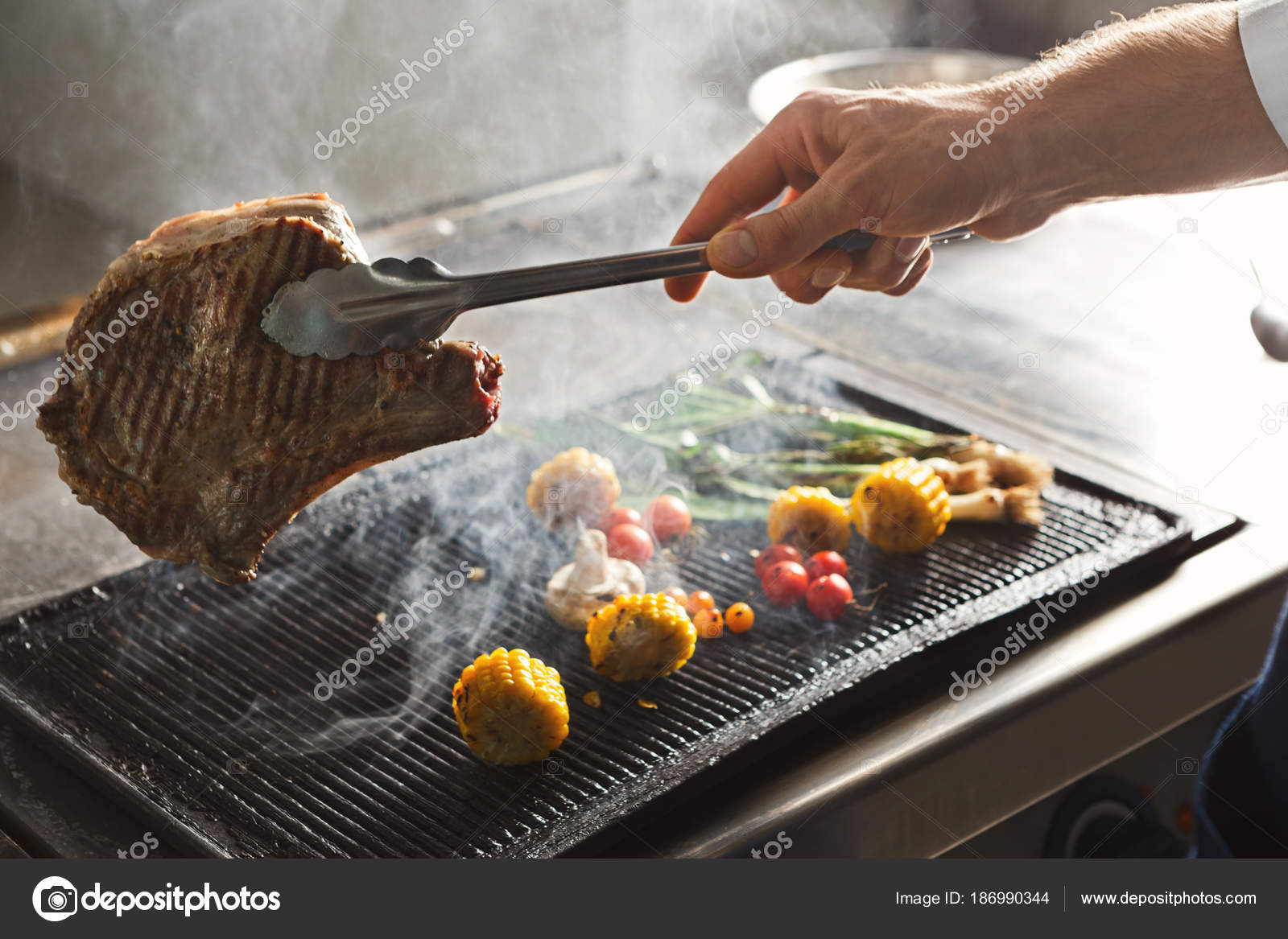 Chef cooking juicy beef steak at restaurant kitchen ⬇ Stock Photo