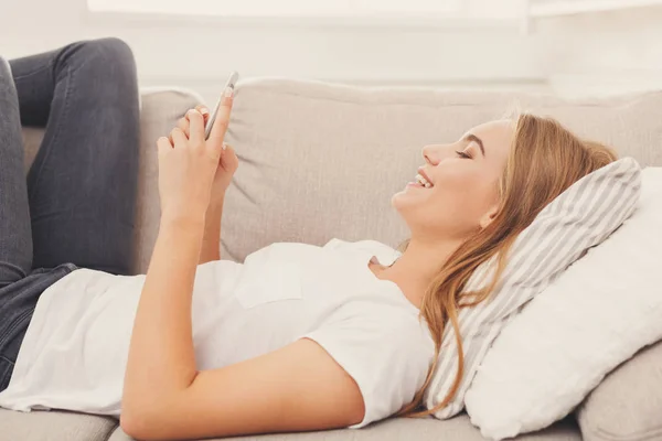 Girl at home chatting online on smartphone — Stock Photo, Image