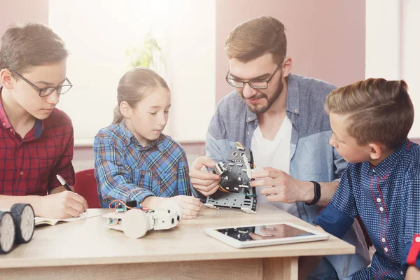 Stem education. Kids creating robots with teacher — Stock Photo, Image