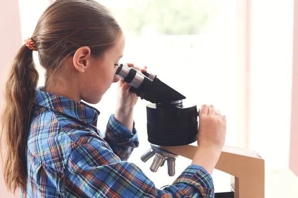 Estudante olhando em microscópio na lição — Fotografia de Stock