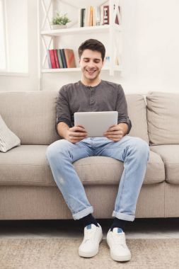 genç adam evde dijital tablet kullanma