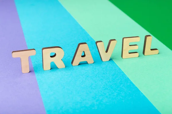 Travel word inscripted with wooden letters on colorful background — Stock Photo, Image