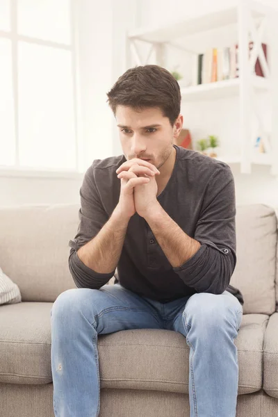 Nadenkend jonge man thuis — Stockfoto