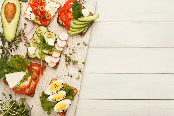 Zdravé vegetariánské sendvičů na bílého dřeva, horní pohled — Stock fotografie