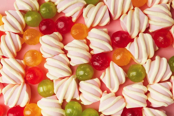 Heap of marshmallows and colourful sweets on pink background — Stock Photo, Image