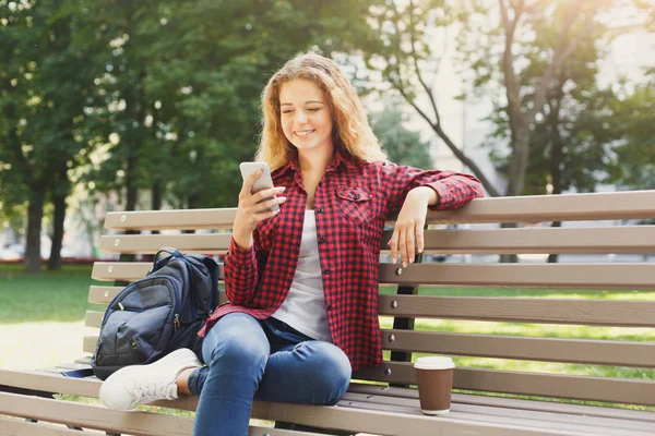 Mulher bonita sentado e usando smartphone ao ar livre — Fotografia de Stock