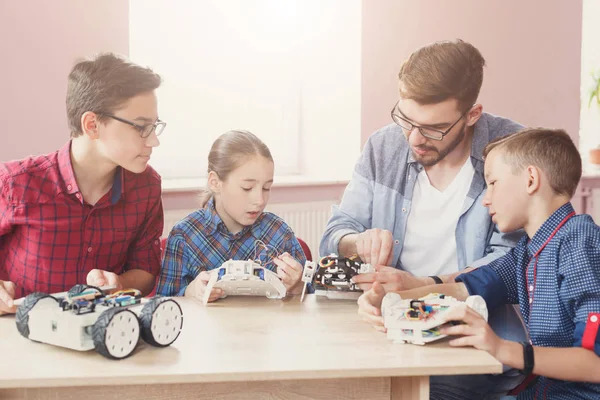 Stem education. Kids creating robots with teacher — Stock Photo, Image