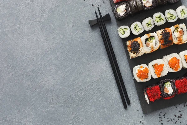 Σύνολο sushi maki και ρολά σε γκρίζο φόντο — Φωτογραφία Αρχείου