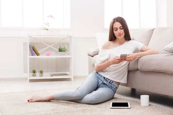 Pensive girl with mobile on the floor — Stock Photo, Image