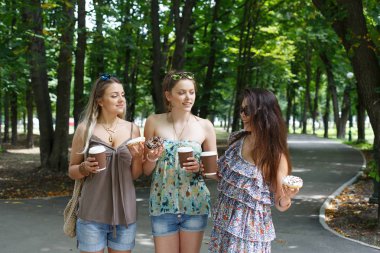 Üç güzel genç boho chic şık kız Parkta yürümek.