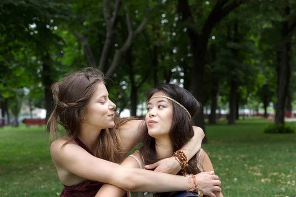 Dvě šťastné mladé dívky obejmout každého jiný v letním parku — Stock fotografie