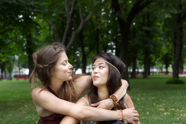 Two happy young girls hug each other in summer park — Stock Photo, Image