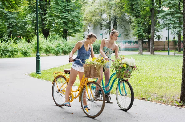 Szczęśliwy boho chic dziewczyny razem jeździć na rowerach w parku — Zdjęcie stockowe