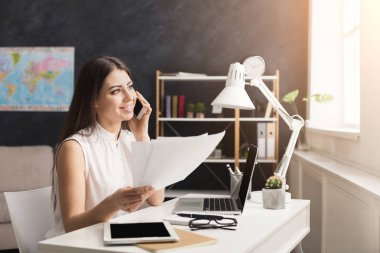 Kız evde dizüstü bilgisayarda çalışan ve cep telefonunuzda konuşuyor