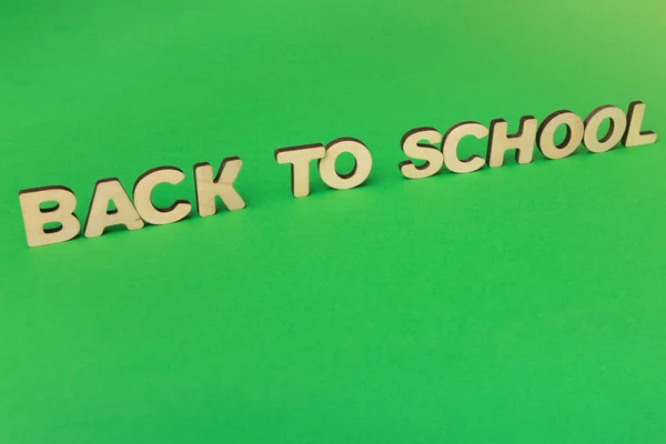 Phrase Back to school made of wooden letters on green background — Stock Photo, Image
