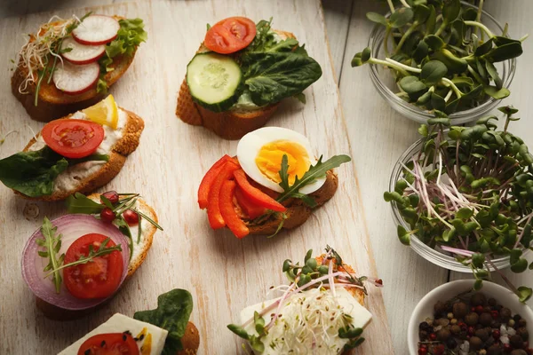 Variety of healthy organic vegetarian sandwiches on white kitchen table — Stock Photo, Image