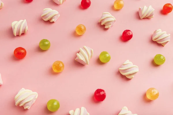 Marshmallow e dolci colorati su sfondo rosa — Foto Stock
