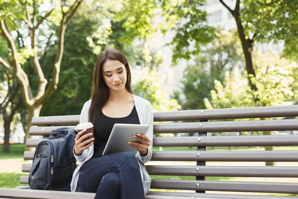 Gülümseyen kadın parkta dijital tablet kullanma — Stok fotoğraf
