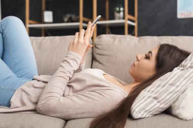 Genç kız evde kanepede mobile ile