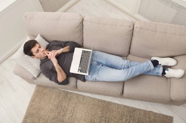 Genç adam evde online üstünde laptop mesajlaşma