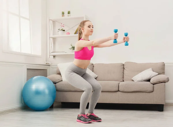 Fitness kvinna gör knäböj hemma — Stockfoto