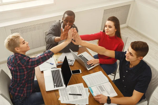 Les gens d'affaires à la table de travail mettre la main ensemble — Photo