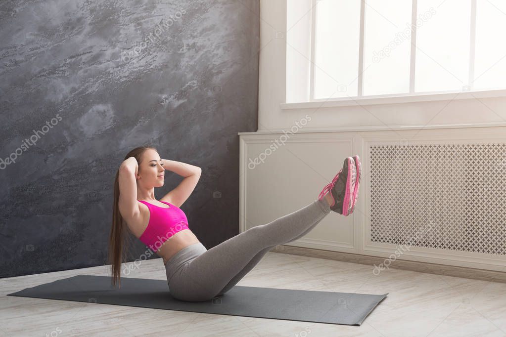 Fitness woman stretching at dark background indoors