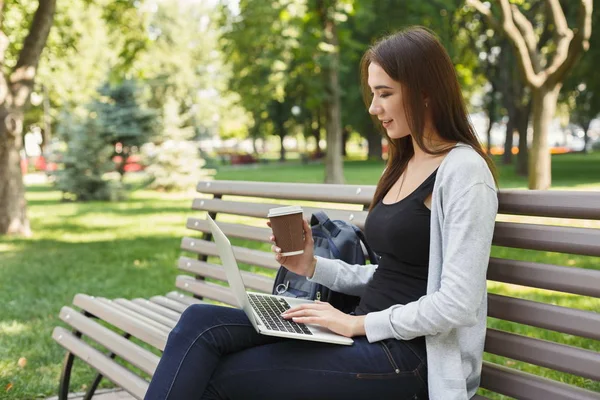 Mujer joven feliz con ordenador portátil al aire libre — Foto de Stock