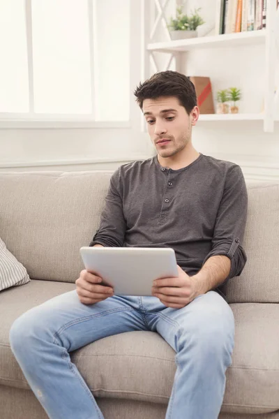 Hombre joven usando tableta digital en casa — Foto de Stock