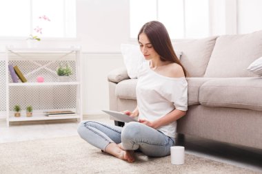 Dalgın kız yerde kahve içme tablet ile