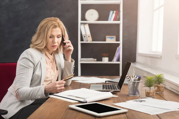 Empresária no trabalho conversando por telefone e fazendo compras online — Fotografia de Stock